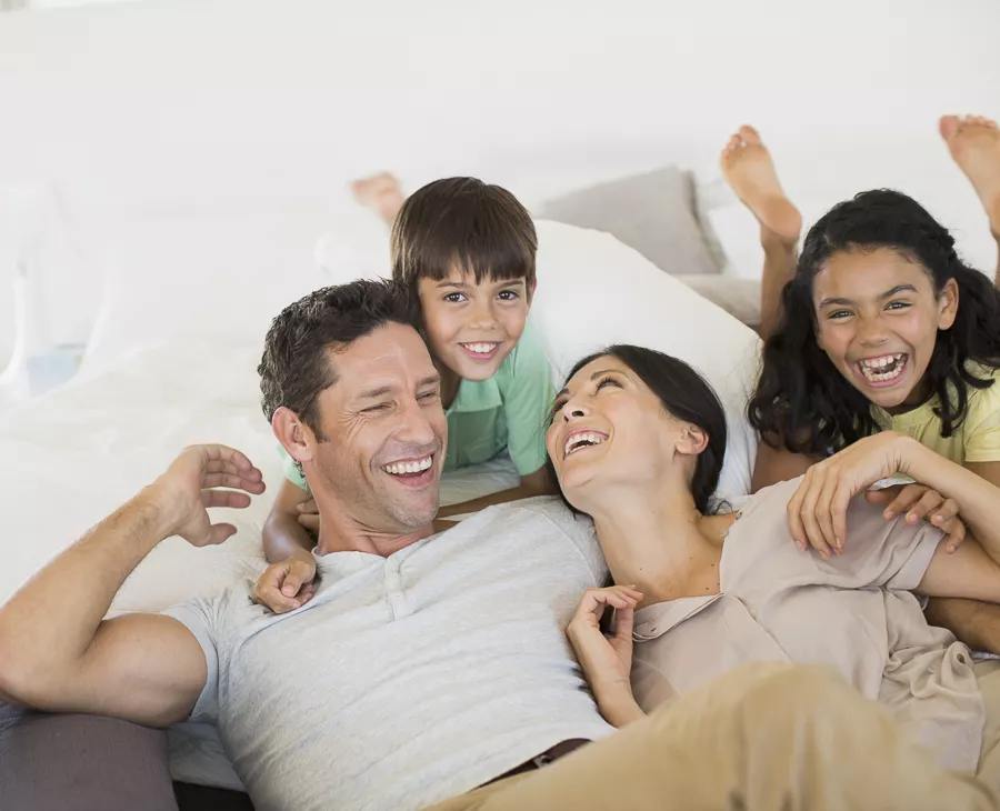 Family laughing and relaxing on sofa